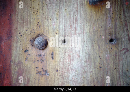 The closeup of a rusty metal surface with rust bubbles and rusty rivets. Stock Photo