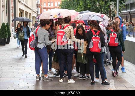 London, UK. 18th Aug, 2017. Tourists outside Harrods caught in a light rain shower in Knightsbridge. Credit: claire doherty/Alamy Live News Stock Photo