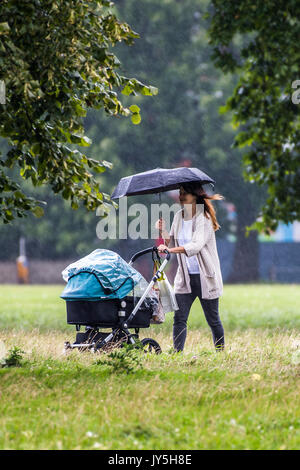 London, UK. 18th August 2017. A sharp downpour catches people out on Clapham Common but it soon passes and the sunshine returns. London 18 Aug 2017. Credit: Guy Bell/Alamy Live News Stock Photo