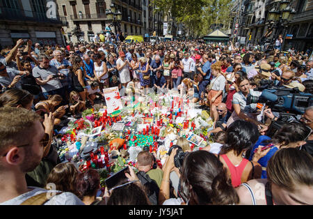 Barcelona, Spain. 18th Aug, 2017. Numerous people have gathered where flowers and candles are put on the ground near the Las Ramblas area in Barcelona, Spain, 18 August 2017. A day prior a truck plowed into a group of people in las Ramblas. Several people were killed and many injured during the terror attack on Thursday. Photo: Matthias Balk/dpa/Alamy Live News Stock Photo