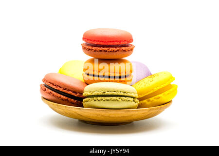Colorful sweet macarons in wooden plate on white background Stock Photo
