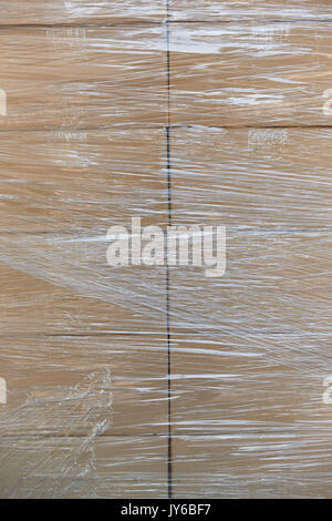 Shrink wrapping on a stacked cardboard boxes. Delivery background Stock Photo