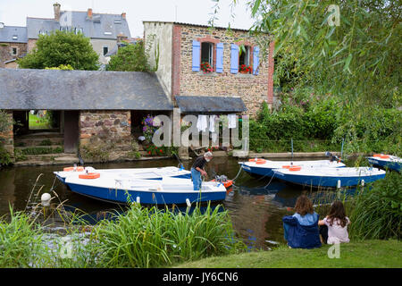 Two children watch the Trieux river at Pontrieux, Côtes-d'Armor, Brittany, France, with traditional washhouses (lavoirs) on the opposite bank Stock Photo