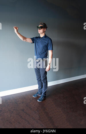 young man working with holographic head set mixing reality Stock Photo