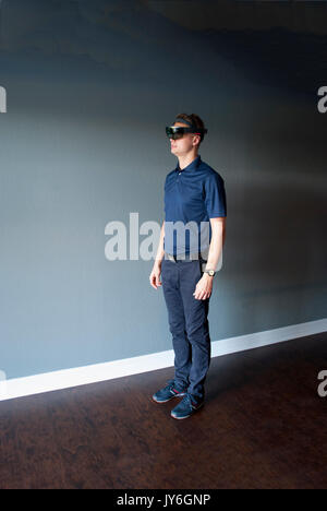 Young engineer in holographic headset creating a virtual surrounding using special gestures - gaze Stock Photo