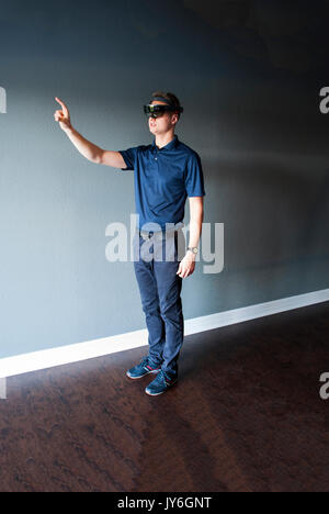 Young engineer in holographic headset creating a virtual surrounding using special gestures - gaze Stock Photo