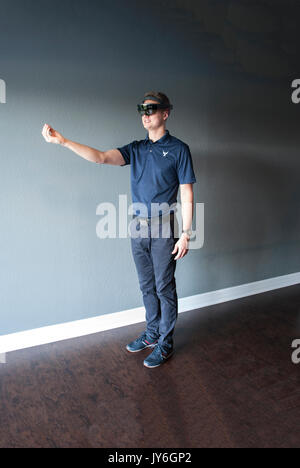 Young engineer in holographic headset creating a virtual surrounding using special gestures - gaze Stock Photo