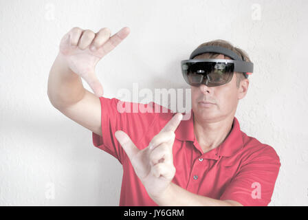 man working with holographic head set mixing reality Stock Photo