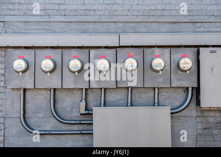 An array of electrical meters recording electric usage, serving a strip mall in Norman, Oklahoma, USA. Stock Photo