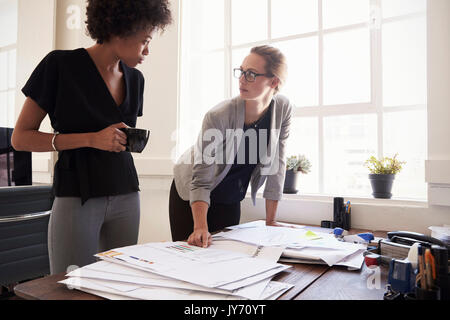 Two young businesswomen discussing work in an office Stock Photo