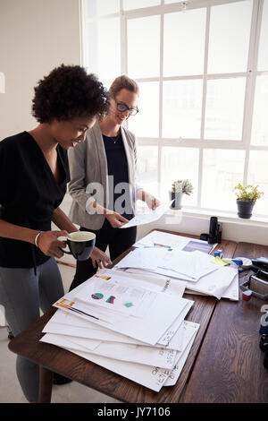 Two happy businesswomen working together in office, vertical Stock Photo
