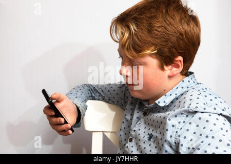 11-year old boy using smartphone Stock Photo