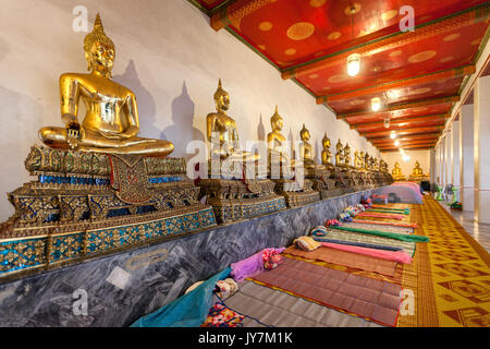 Row of praying golden sitting Buddhas at Wat Pho (Reclining Buddha Temple), Bangkok, Thailand Stock Photo