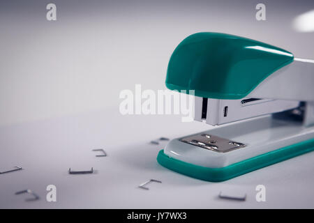 Close-up of stapler and pins on white background Stock Photo