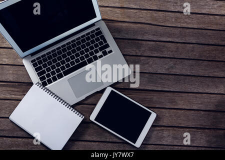 Overhead of laptop, digital tablet and diary on wooden table Stock Photo