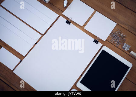 Envelopes with technologies and office supply on wooden table Stock Photo