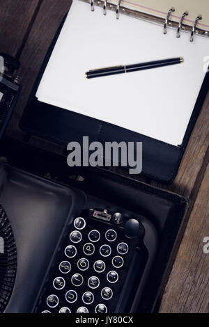 High angle view of typewriter by fountain pen on open diary at table Stock Photo