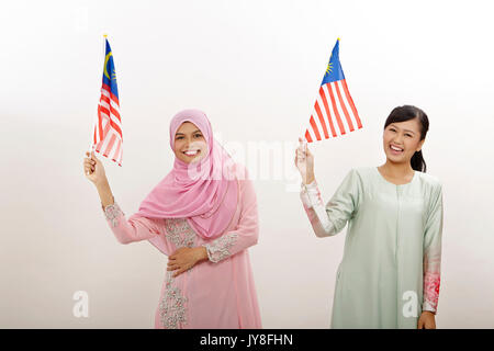 two malay women holding malaysia flag Stock Photo - Alamy