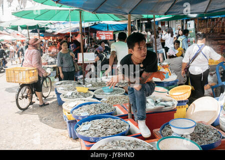 Bankgkok, Thailand - March 25, 2017. A tattooed Thai man selling shrimps in a market. Stock Photo