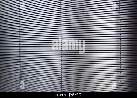 big and gray aluminum blinds behind a window Stock Photo