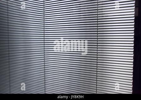 metal blinds behind glass with light irritations through the window Stock Photo