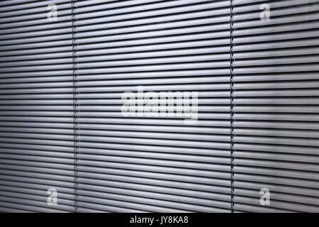 metal shutter behind an office window, blinds behind a window, window blinds and shades window coverings, horizontal slats of metal, awnings Stock Photo