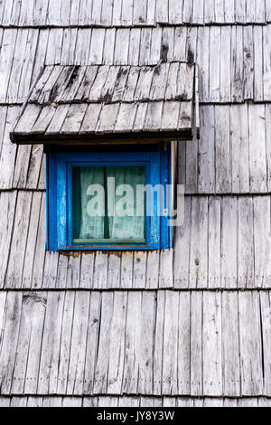 Old Blue Window on Wooden Shingles Roof House Stock Photo