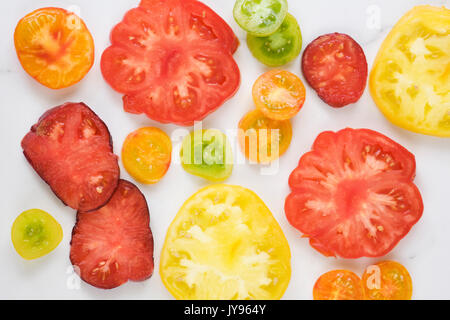 Lycopersicon esculentum. Slices of brightly coloured heritage tomatoes. Stock Photo