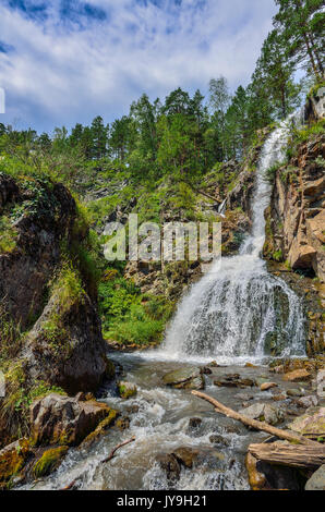 Summer mountain landscape of Kamyshlinsky waterfall in rocks of Altai mountains at bright sunny day with white clouds on a blue sky, Altay Republic, S Stock Photo