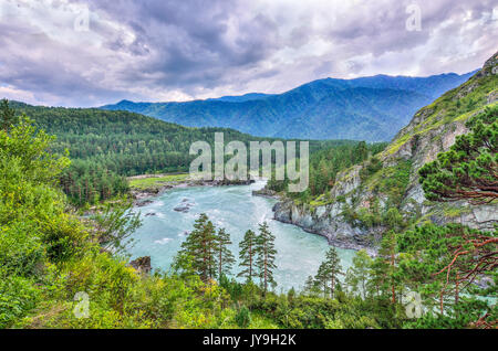 Picturesque summer mountain landscape with fast seething river among the rocky shores covered with forests and dramatic sky - Altai Mountains, Russia. Stock Photo