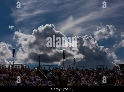 Spectators sitting courtside at Wimbledon Championships 2017, dark clouds gather over ground, London, Great Britain, United Kingdom. Stock Photo