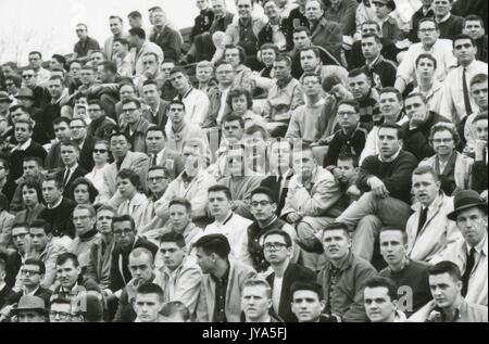 A crowd of mostly student spectators sitting in the stands, watching a Johns Hopkins University lacrosse game, 1960. Stock Photo