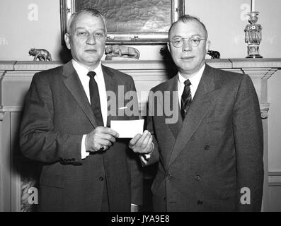 Milton Stover Eisenhower (left), president of Johns Hopkins University, being presented a check, 1965. Stock Photo