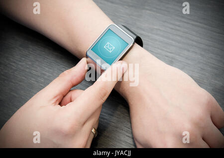 Incoming message notification on smart watch connected to smart phone Stock Photo