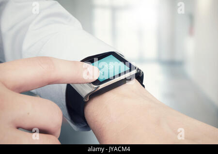 Businessman checking e-mail on modern smart watch. Office in background Stock Photo