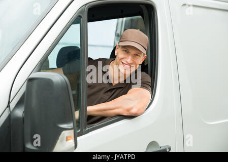 Young Happy Delivery Man Driving Service Delivery Van Stock Photo