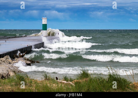 North pier and navigation light at the White Lake Channel taking a pounding from 6 and 7 foot waves rolling in from Lake Michigan. Stock Photo