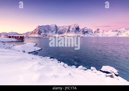 The colors of dawn frames the fishermen houses surrounded by frozen sea Reine Bay Nordland Lofoten Islands Norway Europe Stock Photo