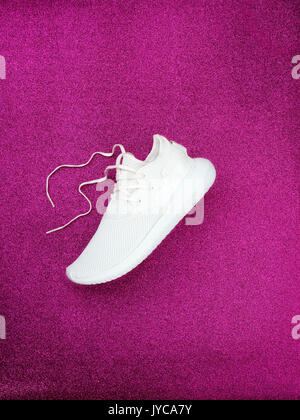white sport shoes with sparkling pink color background Stock Photo