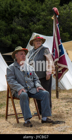 Couple rests in Confederate uniforms during Civil War Reenactment at Duncan Mills on July 14, 2014 Stock Photo