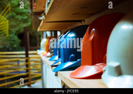 Set of safety colored helmets on a shelf. Stock Photo