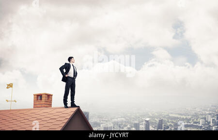 Mister boss on brick roof with arms akimbo. Mixed media Stock Photo