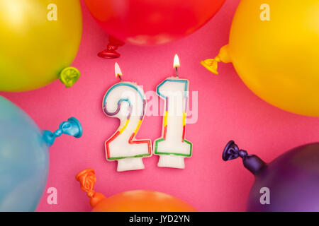 Happy Birthday number 21 celebration candle with colorful balloons and