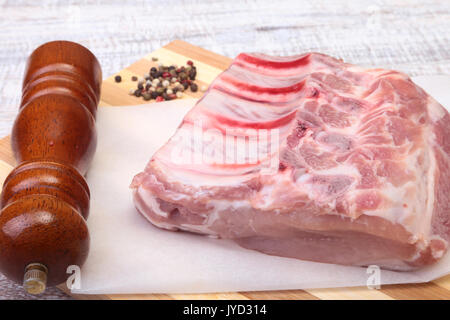 Raw pork chops and spice grinder on cutting board. Ready for cooking. Stock Photo