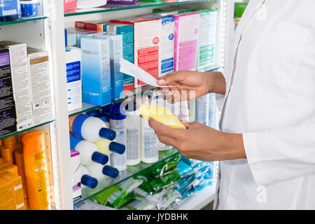 Pharmacist Holding Receipt And Prescription In Pharmacy Stock Photo