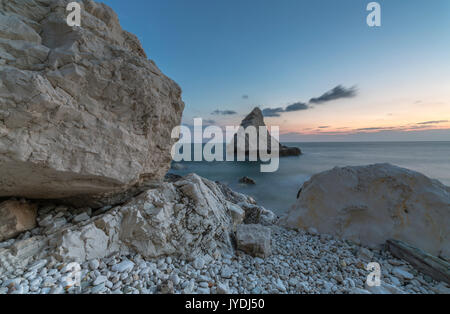 Dusk lights on cliffs framed by clear sea La Vela Beach Portonovo province of Ancona Conero Riviera Marche Italy Europe Stock Photo