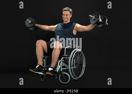 Smiling Handicapped Man On A Wheelchair Working Out With Dumbbell Stock Photo