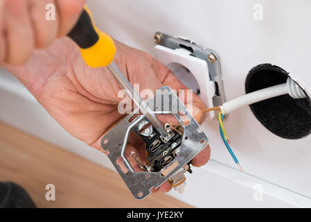 Close-up Of A Technician Fixing Socket With Screwdriver Stock Photo