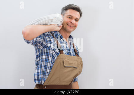 Portrait Of A Smiling Electrician Holding Cable Stock Photo