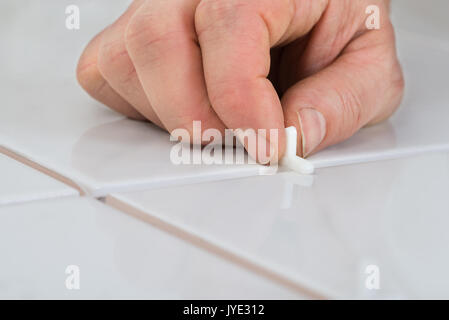 Close-up Of A Person's Hand Placing Spacers Between Ceramic Floor Tiles Stock Photo